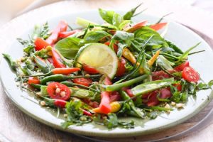 Vibrant and fresh salad with lime, tomatoes, and assorted greens.
